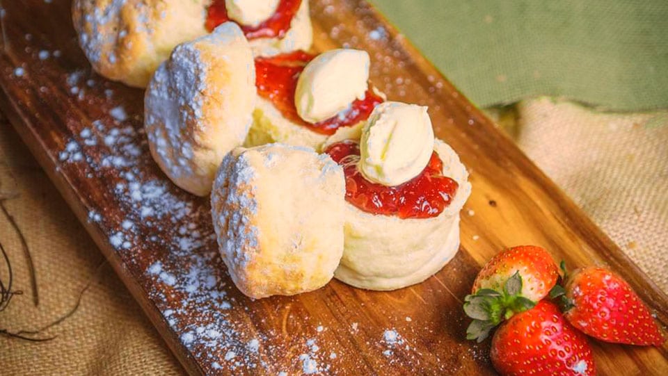 Scones with strawberries on platter board